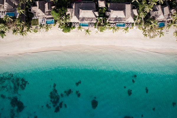 Mar diferentes tonalidades de azul junto a Villas privadas en Kokomo Private Island