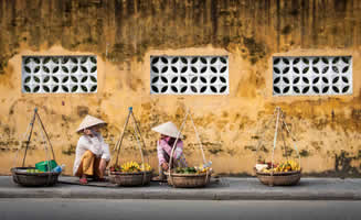 Pared de fondo amarilla con vietnamitas caminando vestimenta tradicional.